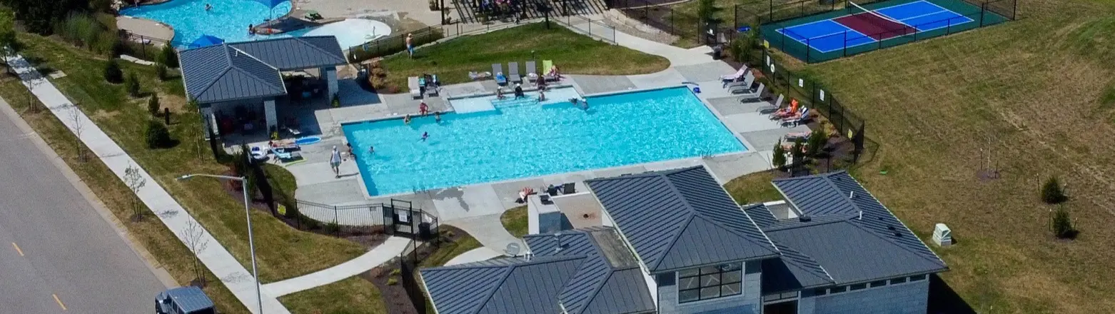 Chapel Hill, Overland Park, Kansas: aerial view of the neighborhood pool with a pool house and the clubhouse beside the street, with lounge chairs around the pool