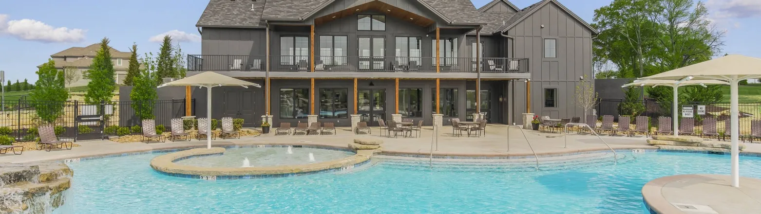Sundance Ridge, Overland Park, Kansas: the community pool with a shallow splash area in front of the clubhouse, with lounge chairs and shade umbrellas