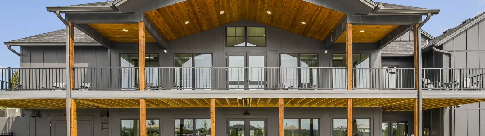 Sundance Ridge, Overland Park, Kansas: the rear of the clubhouse with a covered porch, a wood-paneled gable ceiling and a railed balcony