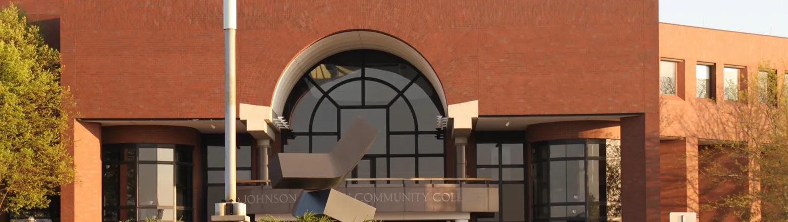 Johnson County Community College, Overland Park, Kansas: the Carlsen Center's brick entrance with an arched window and the college's name lettering behind a sculpture