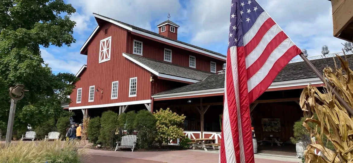 Deanna Rose Children's Farmstead, Overland Park, Kansas: the red barn beside a brick path, with an American flag in the foreground
