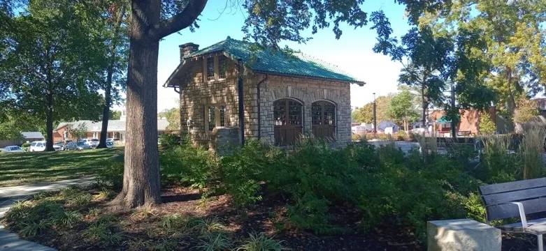 Thompson Park, Overland Park, Kansas: a stone shelter house with a green roof among trees and planting beds