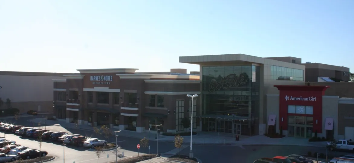 The Oak Park Mall exterior in Overland Park, Kansas, a wide daylight view of the mall entrance and storefronts above the parking lot